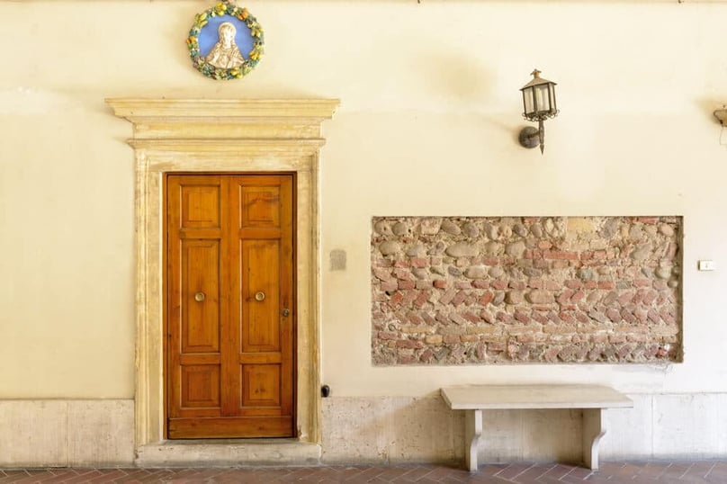  A photo of a wood security door leading to an old home on the streets of Italy.