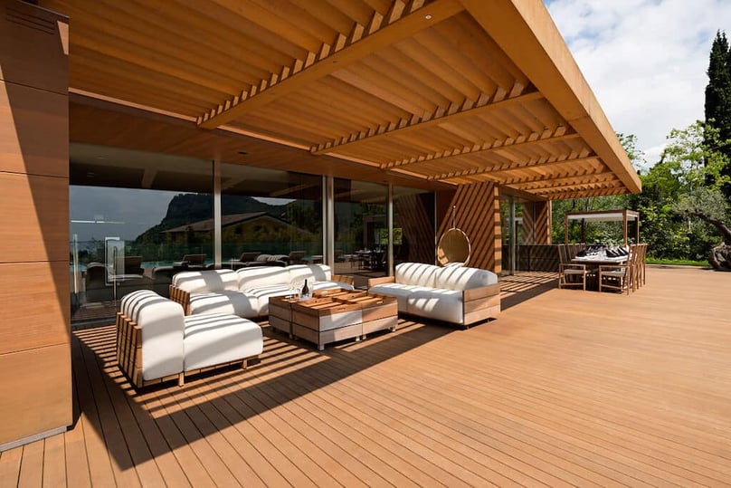 A photo of floor to ceiling sliding glass doors featuring security glass, leading out to a luxurious deck.