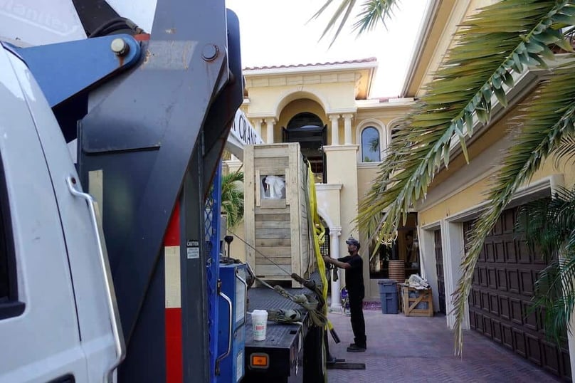 A photo of a custom security door being delivered to a luxury residence for installation.
