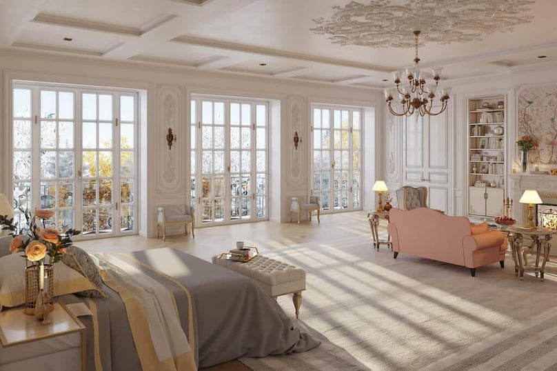 A photo of three sets of french doors leading out to a patio outside a luxury home. 