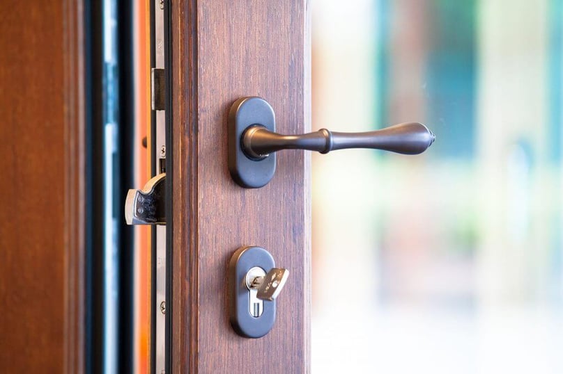 A close-up photo of a glass door with a high security lock installed.