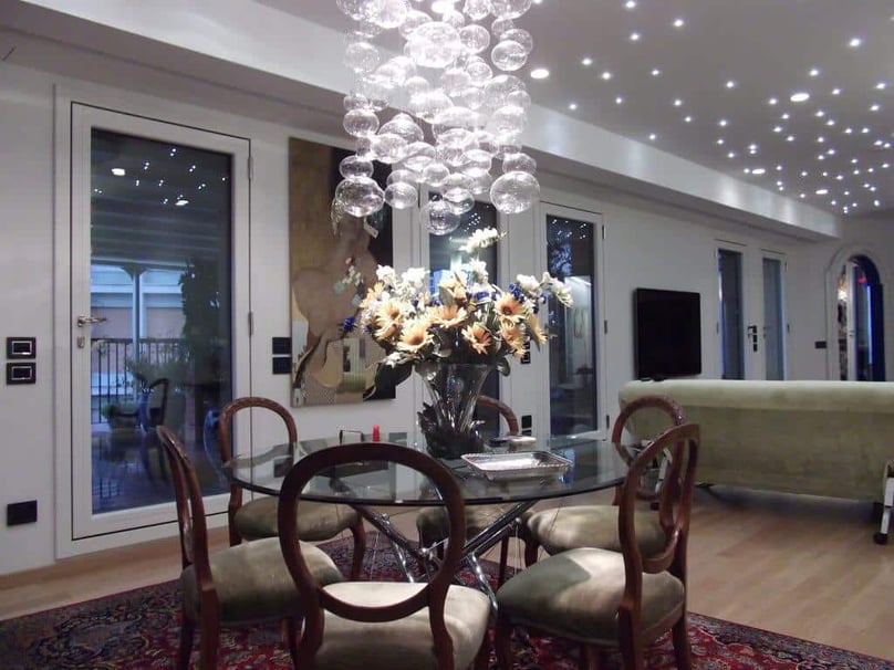 A photo of the interior of a luxury home with glass security doors leading onto a spacious patio.