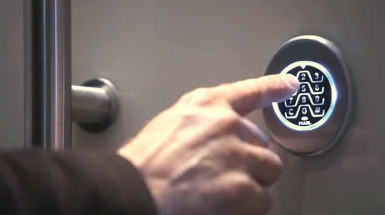 A photo of someone typing a code into a home security keypad.