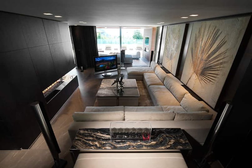 A photo of a cozy living room in a luxury home overlooking a patio and a pool.