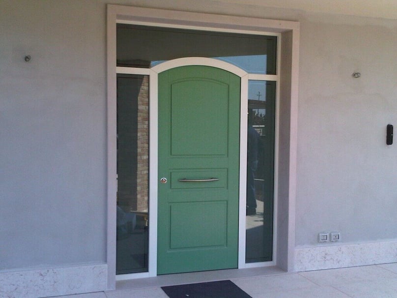 A photo of a custom luxury front door framed by security glass.