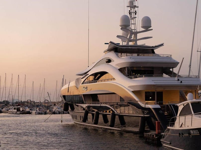 A photo of a luxury yacht docked at sunset.