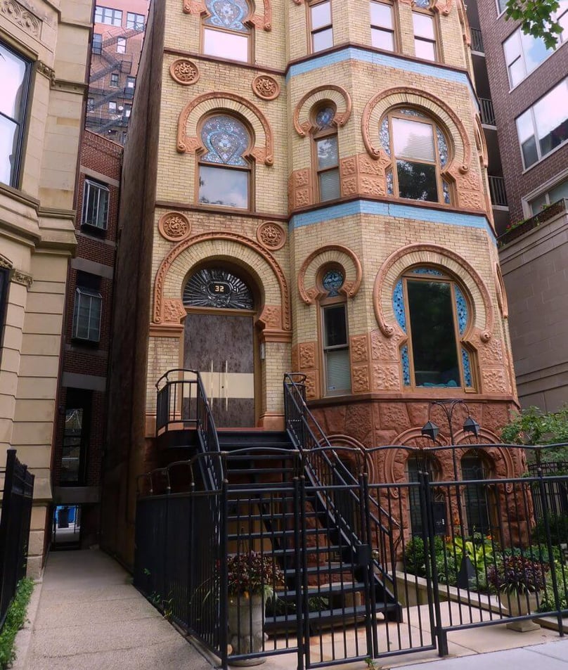A photo of a three-story townhome with a custom luxury front door.
