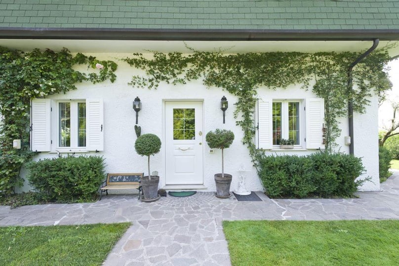 A photo of the front entrance to a villa with hurricane certified windows and a door.